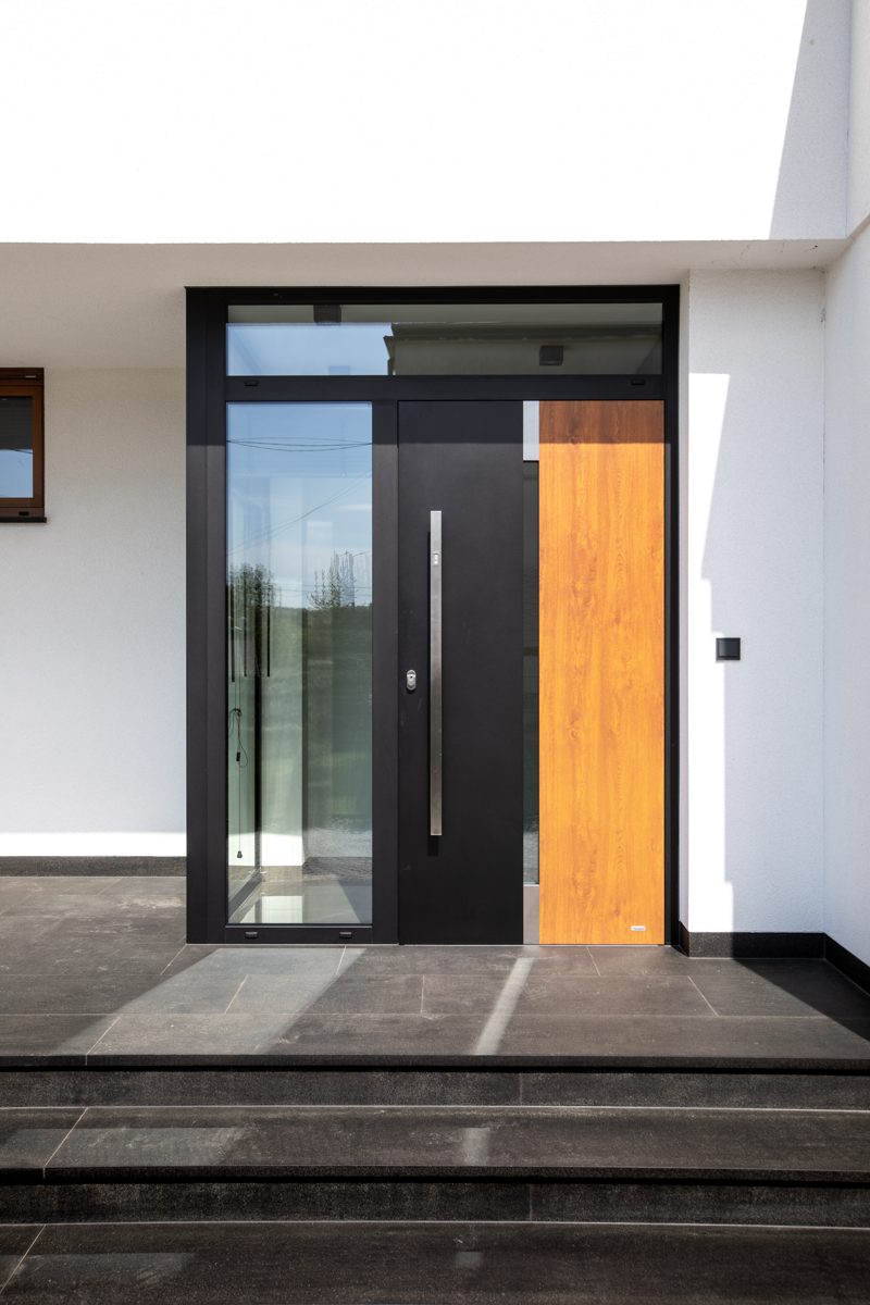 Dark front door with a glass side panel and a timber-effect panel under a glazed top