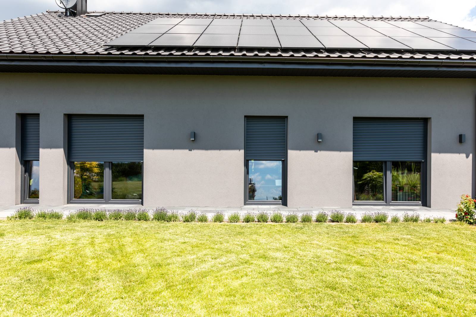 Grey house with roller shutters over the windows