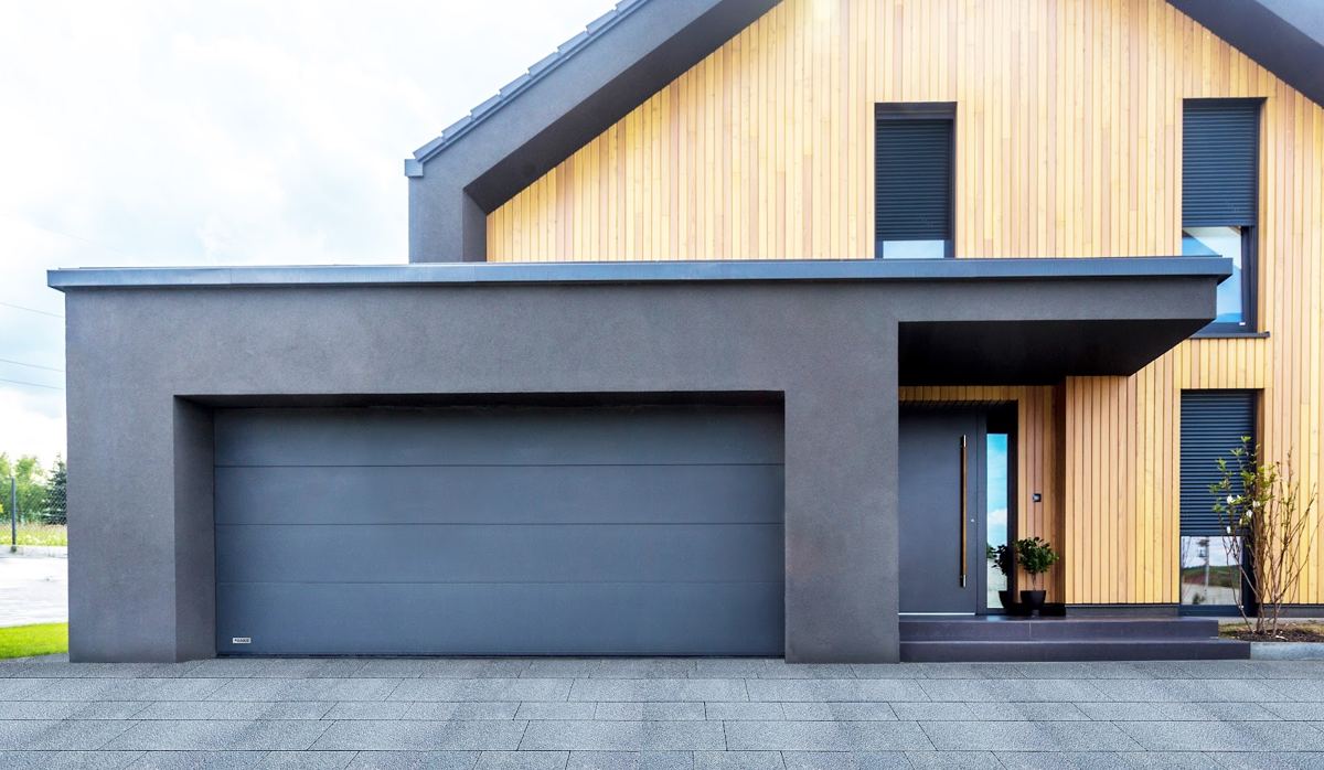 Timber-clad house with a wide anthracite garage door