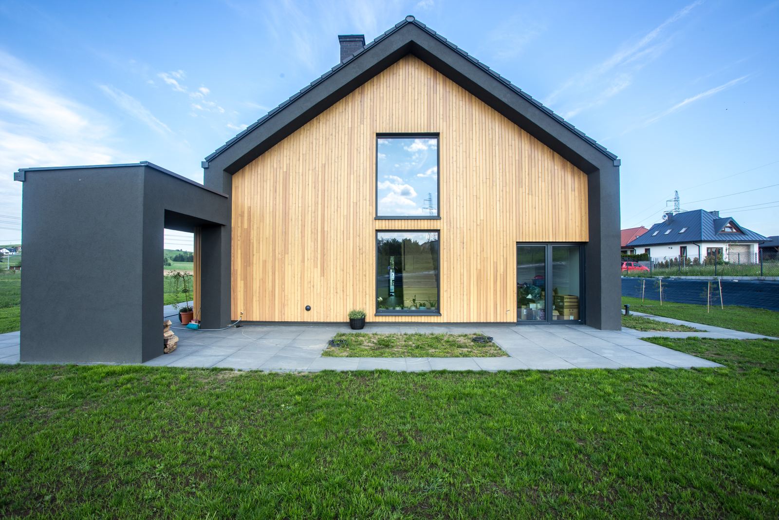 Timber-clad gable end with tall dark-framed windows