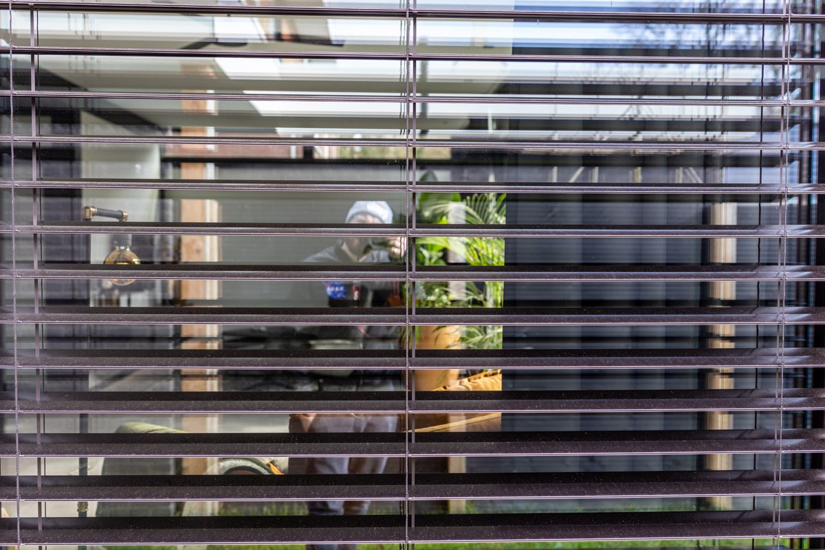 Close view of dark venetian blind slats with the room visible through them